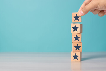 Hand placing wooden blocks with star icons to represent increasing rating, ranking, and customer satisfaction, with copy space. Ideal for business, review systems, and service quality.