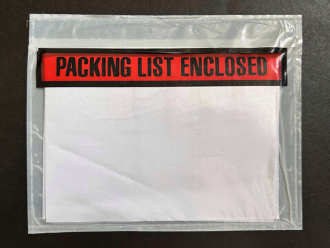Transparent adhesive pouch containing documents with bold red label stating "Packing List Enclosed" on a dark background