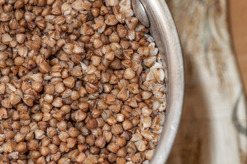 Plate with tasty buckwheat porridg.Boiled buckwheat porridge in ceramic pot on wooden background.