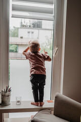 Kleiner Junge zu Hause am Fenster - neugierig, entdecken, Kind sein 