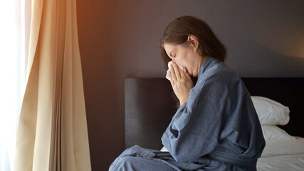 Sick tourist woman blowing nose and crying at hotel