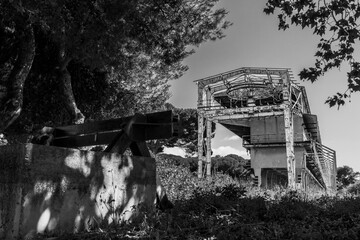 An abandoned industrial facility with a train battering ram in the foreground. Black and white...