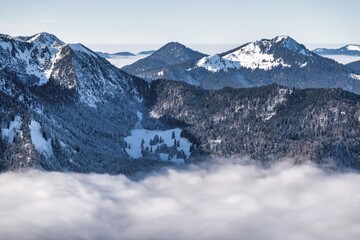 winter mountain landscape with snow, fog and cloud covered areas