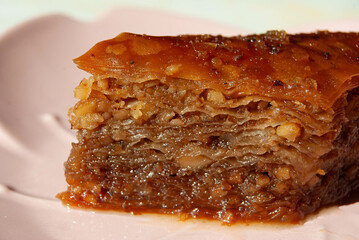 Sweet layered baklava on a pink ceramic plate