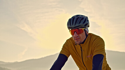 Close-up shot of a man in a yellow shirt and helmet riding a bike, showcasing his active lifestyle...