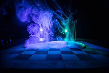 Chess board game concept of business ideas and competition. Chess figures on a dark background with smoke and fog.