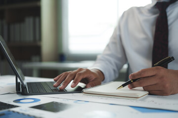 Businessman working with tablet and taking notes in office meeting