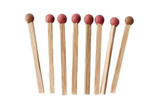 A group of six wooden matches with red tips arranged against a black background in a studio shot