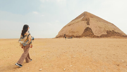 Tourist walking towards the bent pyramid in the desert of dahshur, egypt