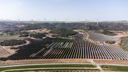 Solar panels and wind turbines generating clean energy in vast landscape