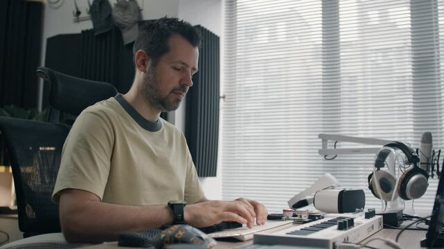 Focused music producer works on audio project in a modern soundproof home studio