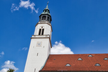 From bottom to top view of the tower and roof of Celle's town church against a blue sky