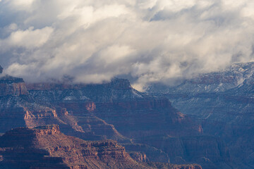 Naklejka premium Dramatic views of mountains and valleys touching the clouds at sunrise in Grand Canyon
