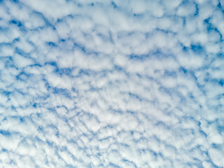 The sky is blue with many clouds. The clouds are white and fluffy. The sky is clear and bright