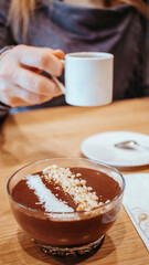 Cup of espresso with chocolate dessert topped with coconut and crispy pearls