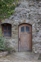 wooden door and small window in the wall of a stone castle