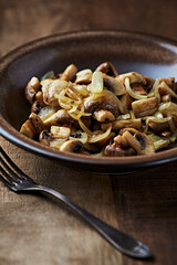 Onion with mushrooms. Rustic wooden background.	