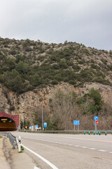 asphalt road leading to a tunnel in the mountains