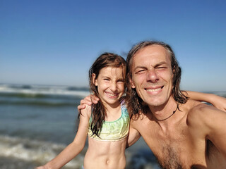 Portrait of father and young daughter on the beach in summer vacation