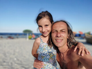 Portrait of father and young daughter on the beach in summer vacation