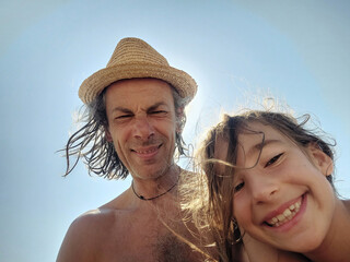 Portrait of father and young daughter on the beach in summer vacation