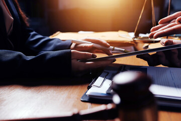 Attractive young lawyer in office Business woman and lawyers discussing contract papers with brass scale on wooden desk in office. Law, legal services, advice, Justice and real estate concept.