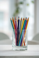 multi-colored pencils in a transparent glass cup

