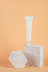 Plastic white tube for cream or lotion. Skin care or sunscreen cosmetic with stylish props on cream...