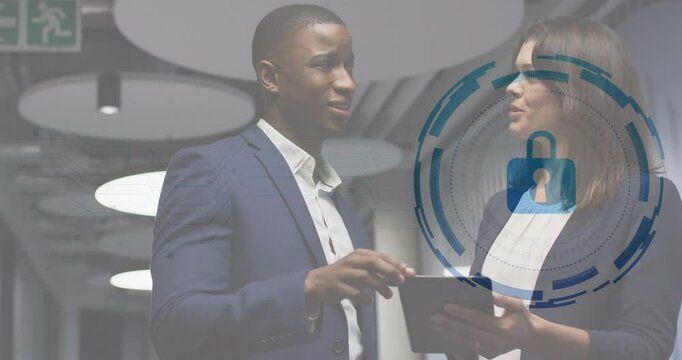 Man tapping tablet and woman nodding in office corridor while digital lock graphic showing security - Powered by Adobe