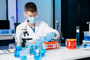 Fototapeta premium male scientist working with micro pipettes analyzing biochemical samples, advanced science