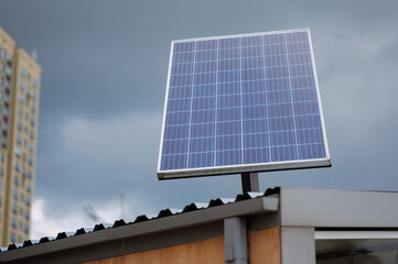 modern solar panel on building roof signifies renewable energy innovation against cloudy sky....