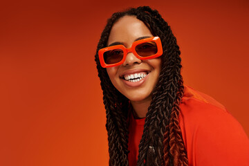 Bright casual style shines through with confidence against a vibrant orange backdrop