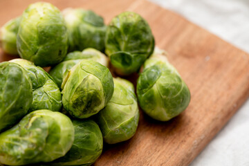 Closeup of green Brussel sprouts on a wooden cutting board