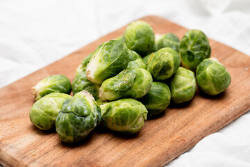 Bright Green Brussel sprouts on a wooden cutting board on the table