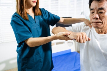 Obraz premium Female physiotherapist supports arm movement exercise for senior male patient during rehabilitation. Elderly care