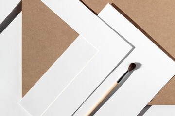 Design Studio Flatlay. Kraft Paper, Passepartout, Cardboard, Painting Brush Arranged on Desk....