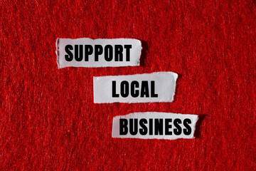 Support local business message written on ripped torn white paper pieces on red background. Conceptual support local business symbol. Copy space.