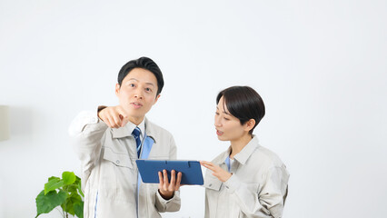 タブレットを見ながら建物を点検する作業員グループ