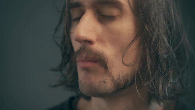 Introspective Man with Disheveled Hair and Playful Mustache Embraces Serenity