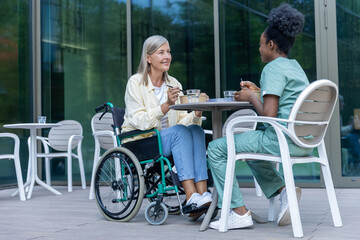 Nurse and female patient having lunch in the clinic yard and looking involved