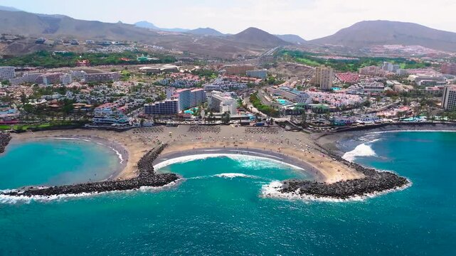 Troya beach with clear waters and coastal town in tenerife, aerial view