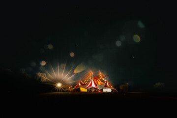 Red and white big top circus tent visiting small town in rural Australia illuminated at night under