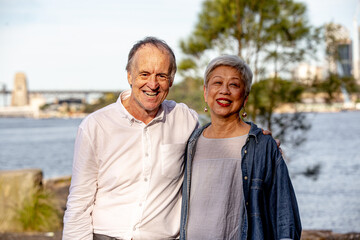 Portrait of happy senior couple standing near the water