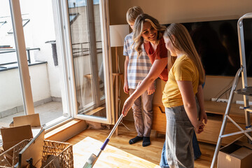  A mother and her kids are unpacking boxes and moving into their new home. They work together to organize their belongings and make the space feel like home. 