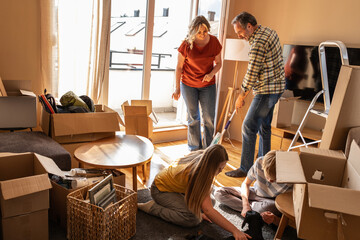 A married couple is cleaning their new apartment together. They organize belongings, wipe surfaces, and prepare the space to feel like home. 