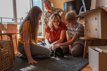 A family is moving into a new apartment, unpacking boxes together in the living room. They organize their belongings and start setting up their new home. 