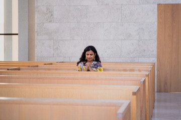 young woman praying in a Catholic church 