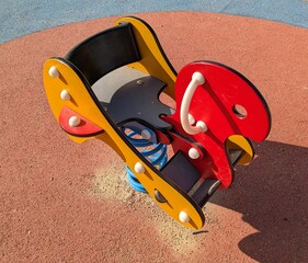Vista de cerca de un balancín infantil con forma de animal en parque público