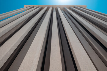 Low Angle View of Contemporary Architectural Structure, tall pillars against blue sky, Architectural photography off museum exterior in Abu Dhabi

