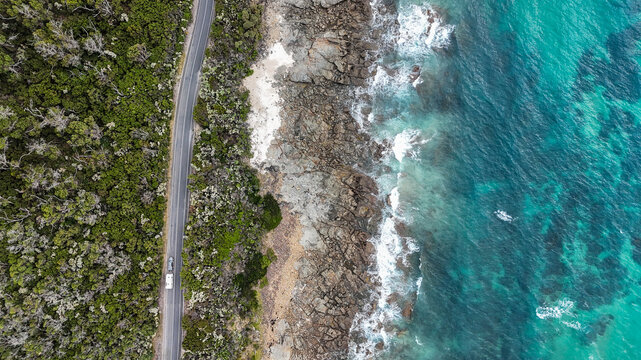 Aerial of straight road parallel to ocean